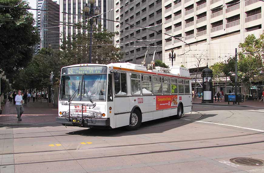 An SF Muni trolley bus on the 14 Mission line makes a turn downtown in September 2015.